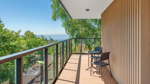 a balcony with two chairs and a table on it at Apartamenty Helski Brzeg in Hel