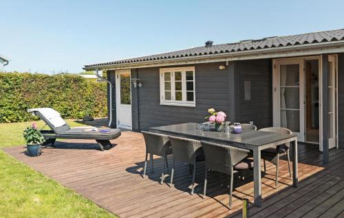 a wooden deck with a table and chairs on a house at Gorgeous Home In Karrebæksminde in Karrebæksminde