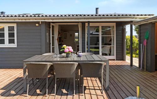 a wooden table with chairs on a deck at Gorgeous Home In Karrebæksminde in Karrebæksminde