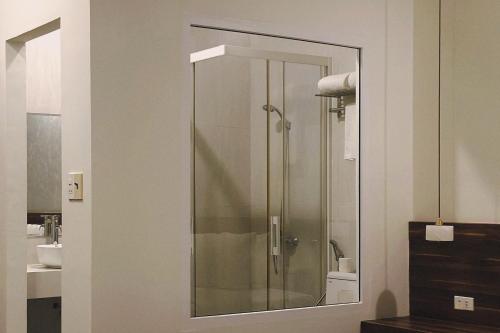 una doccia con una porta in vetro in un bagno di Hong Nhan Hotel a Da Lat