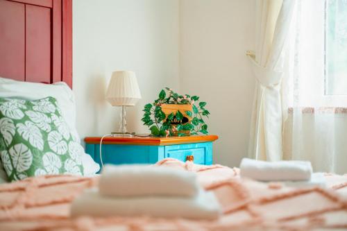 a bed with a blue table with a plant on it at Hotel Ostende in Chocerady