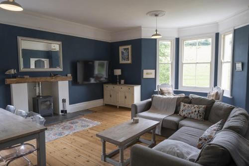 a living room with a couch and a tv at Vine House, Bantham in South Devon near to beach in peaceful rural location in Bantham