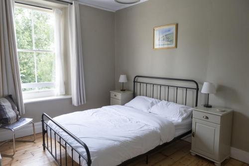 a bedroom with a bed and a chair and a window at Vine House, Bantham in South Devon near to beach in peaceful rural location in Bantham