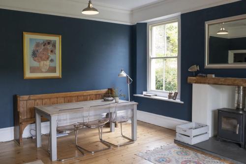a living room with a table and a fireplace at Vine House, Bantham in South Devon near to beach in peaceful rural location in Bantham