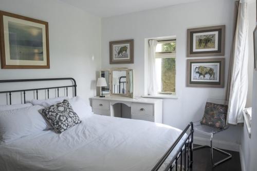 a white bedroom with a bed and a window at Vine House, Bantham in South Devon near to beach in peaceful rural location in Bantham