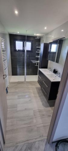 une salle de bain avec douche et lavabo dans l'établissement Maison, à Saint-Léonard