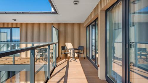a balcony with glass doors and a table and chairs at Apartamenty Helski Brzeg in Hel