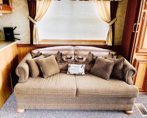 a couch in a living room with a window at Maggie Valley Cabin Rentals in Maggie Valley