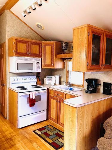 a kitchen with wooden cabinets and a white stove top oven at Maggie Valley Cabin Rentals in Maggie Valley