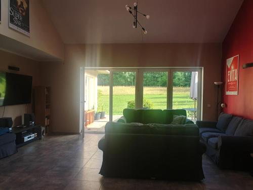 a living room with a couch and a sliding glass door at Kuniec Świata in Błotnia