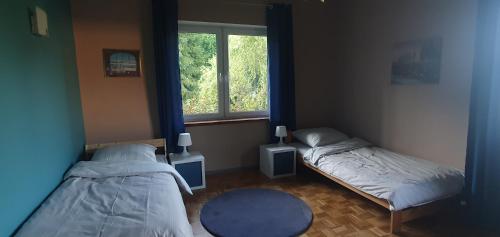 a bedroom with two beds and a window at Kuniec Świata in Błotnia