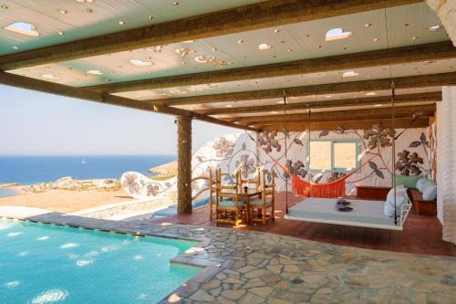a house with a swimming pool with a view of the ocean at Agalia Luxury Suites in Tzamaria