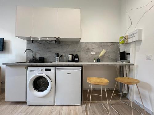 une cuisine avec un lave-linge et deux tabourets dans l'établissement Studio Sydney - Jean Médecin - LA RIVIERA LCD, à Nice