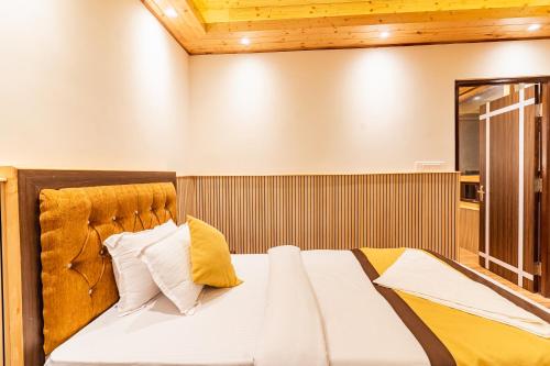 a bedroom with a large bed with yellow pillows at The Golden Retreat Hotel in Pelling in Pelling