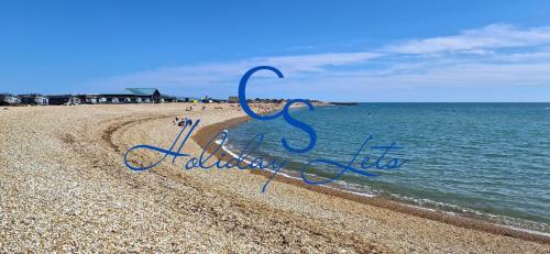a sign on a beach with the word addiction at Riverwood Lodge, The Boulevard, Seal Bay, Selsey in Selsey