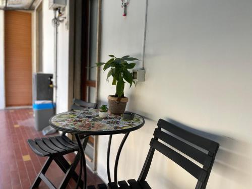 a table with a potted plant on it next to two chairs at Casa Piemont in Casale Monferrato