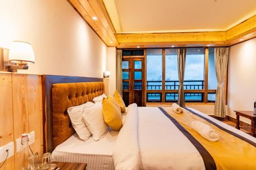 a bedroom with a large bed with yellow pillows at The Golden Retreat Hotel in Pelling in Pelling