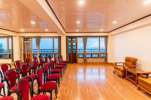 a lecture room with red chairs and a whiteboard at The Golden Retreat Hotel in Pelling in Pelling