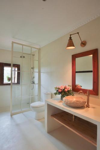 a bathroom with a toilet and a sink and a mirror at Mukima Manor in Nanyuki