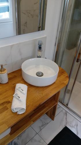 un lavabo blanc sur un comptoir en bois dans une salle de bain dans l'établissement Le sublime SM, à Paris
