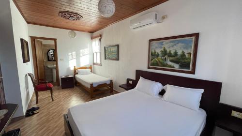 a bedroom with a bed and a desk and a chair at Denis GuestHouse 1930 in Gjirokastër