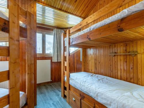 Ce lit se trouve dans un dortoir doté de 2 lits superposés et de murs en bois. dans l'établissement Spacieux appartement 8 pers avec WiFi, balcon et cuisine rénovée - FR-1-694-94, à Val dʼIsère