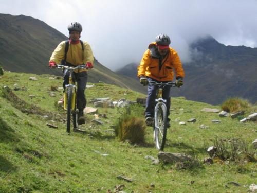 twee mensen die fietsen op een grasheuvel bij Casa Manzanapata in Cuzco