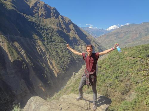 een man die op een rots staat met een waterfles bij Casa Manzanapata in Cuzco