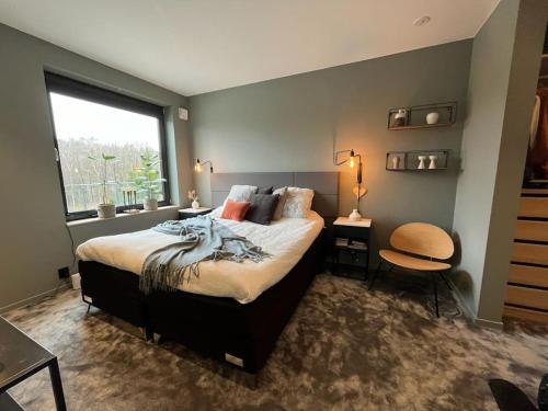 a bedroom with a large bed and a window at Large pool villa, roof terrace near lake & nature in Floda