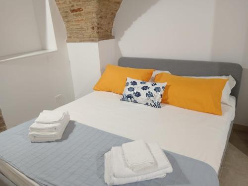 un letto con asciugamani arancioni e bianchi di GiuattyHomeHolidayTermoli2 a Termoli