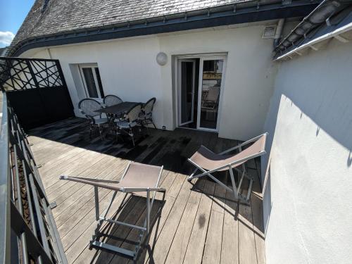a deck with chairs and a table on a house at Studio au coeur de Plouharnel in Plouharnel