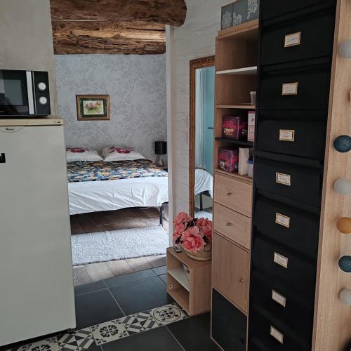 une chambre avec un lit et une commode avec un miroir dans l'établissement Le gîte du courtil, à Tressé