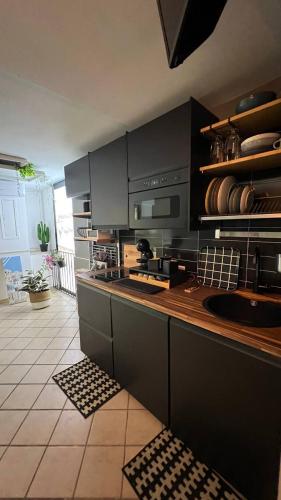a kitchen with black cabinets and a counter top at La stanza sul Porto in Pozzuoli