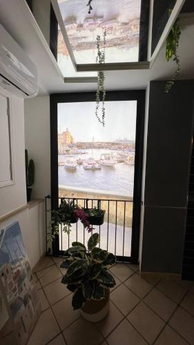 a room with a large window with a view of the water at La stanza sul Porto in Pozzuoli