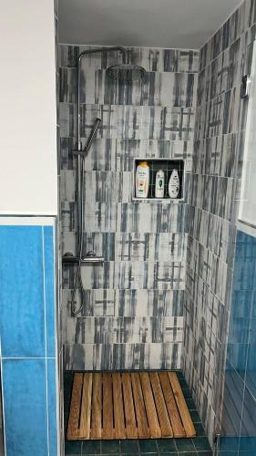 a shower with a wooden floor in a bathroom at La stanza sul Porto in Pozzuoli