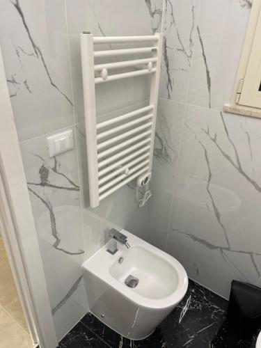a white toilet in a bathroom with marble walls at Therma Luxury house in Termoli
