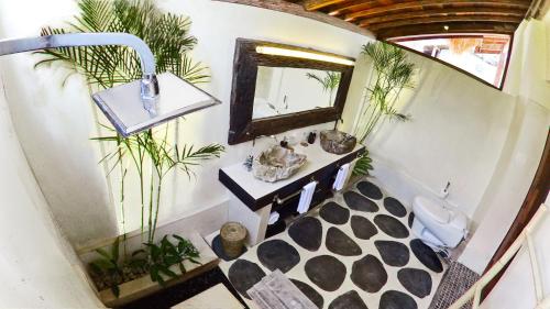 a bathroom with a mirror and a sink and plants at Kaleydo Villas in Gili Trawangan