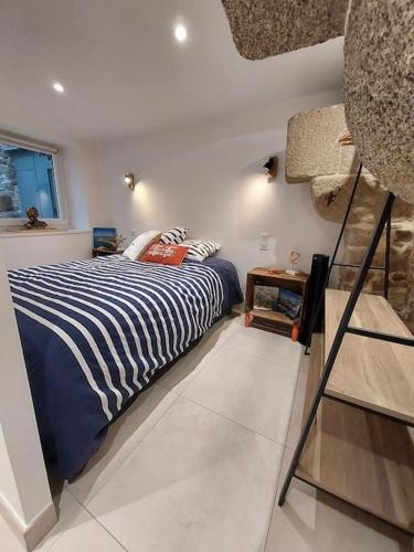 une chambre avec un lit avec une couverture rayée bleue et blanche dans l'établissement La Porte Saint Mi-Sel, Gîte au coeur de la cité médiévale, à Guérande