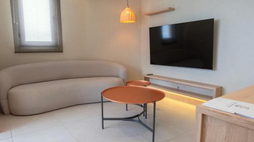 a living room with a couch and a table and a tv at Kleopatra Dreams Beach Hotel in Alanya