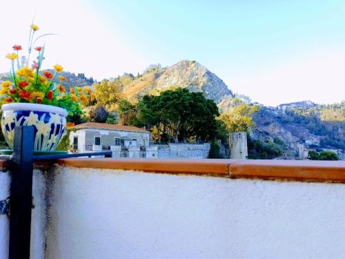 a vase filled with flowers sitting on a ledge at Hotel Pensione Cundari in Taormina