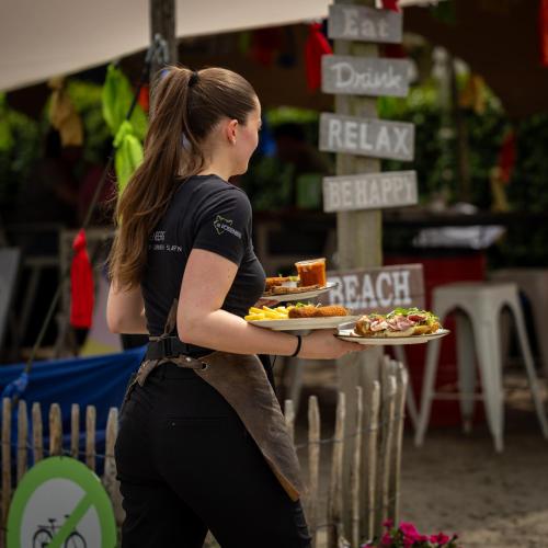 a woman is holding a tray of food at Hotel Restaurant 'de Vossenberg' in Vierhouten