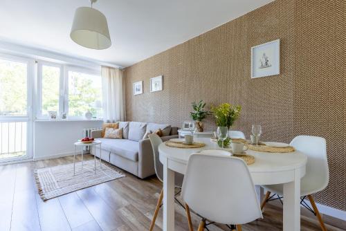 a living room with a white table and white chairs at Krofey Jelitkowo Gdańsk in Gdańsk