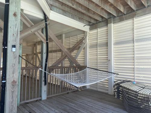 a hammock on the porch of a house at Most Requested 16 Br Oceanfront Home in Holden Beach in Holden Beach