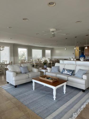 a living room with white couches and a coffee table at Most Requested 16 Br Oceanfront Home in Holden Beach in Holden Beach