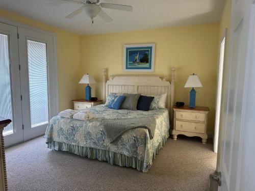 a bedroom with a bed with blue pillows and a fan at Most Requested 16 Br Oceanfront Home in Holden Beach in Holden Beach