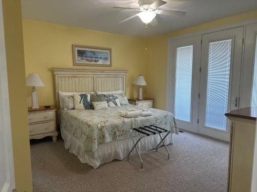a bedroom with a bed and a ceiling fan at Most Requested 16 Br Oceanfront Home in Holden Beach in Holden Beach