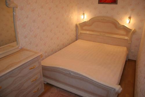 a small bedroom with a bed and a dresser at Naiza Guesthouse and Apartments in Jūrmala