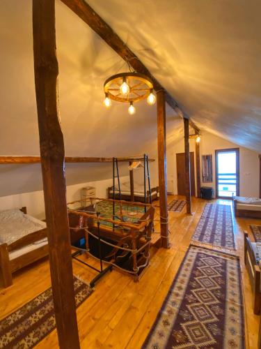 a room with a wooden floor and a room with a table at Chalet Motilor Straja in Lupeni