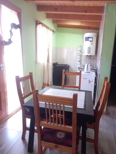 Una mesa de comedor y sillas en una cocina. en Cabaña del Lago, en San Carlos de Bariloche