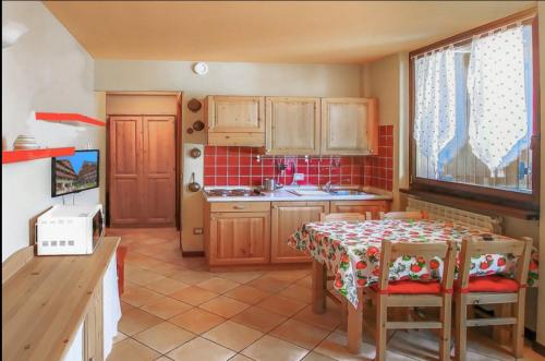 a kitchen with a table and a table and chairs at Borgo Stalle in Prato Nevoso